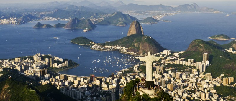 Vista aérea del Cristo Redentor sobre Río de Janeiro, con el Pão de Açúcar y la bahía de Guanabara bajo un cielo azul