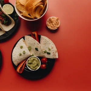 Una mesa con tacos, quesadillas, guacamole y salsas típicas de la cocina mexicana