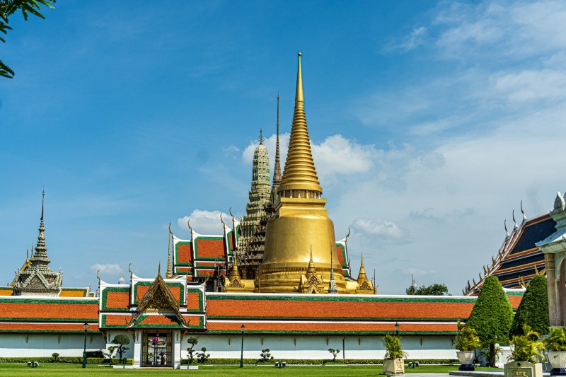 El Gran Palacio Real de Bangkok, con sus tejados dorados y rojos, bajo un cielo azul despejado
