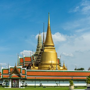El Gran Palacio Real de Bangkok, con sus tejados dorados y rojos, bajo un cielo azul despejado