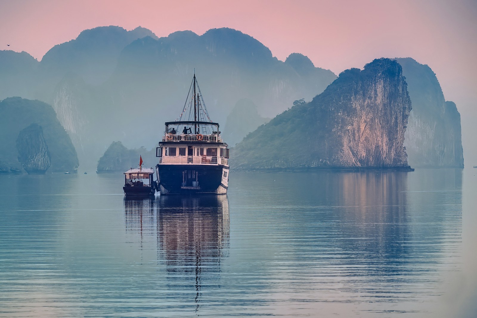 Barco navegando entre los islotes de piedra caliza de la bahía de Ha Long, en Vietnam