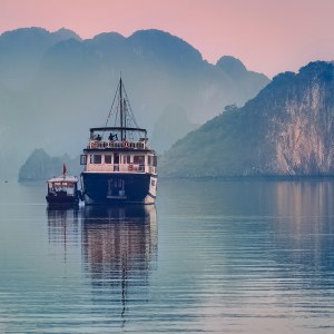 Barco navegando entre los islotes de piedra caliza de la bahía de Ha Long, en Vietnam