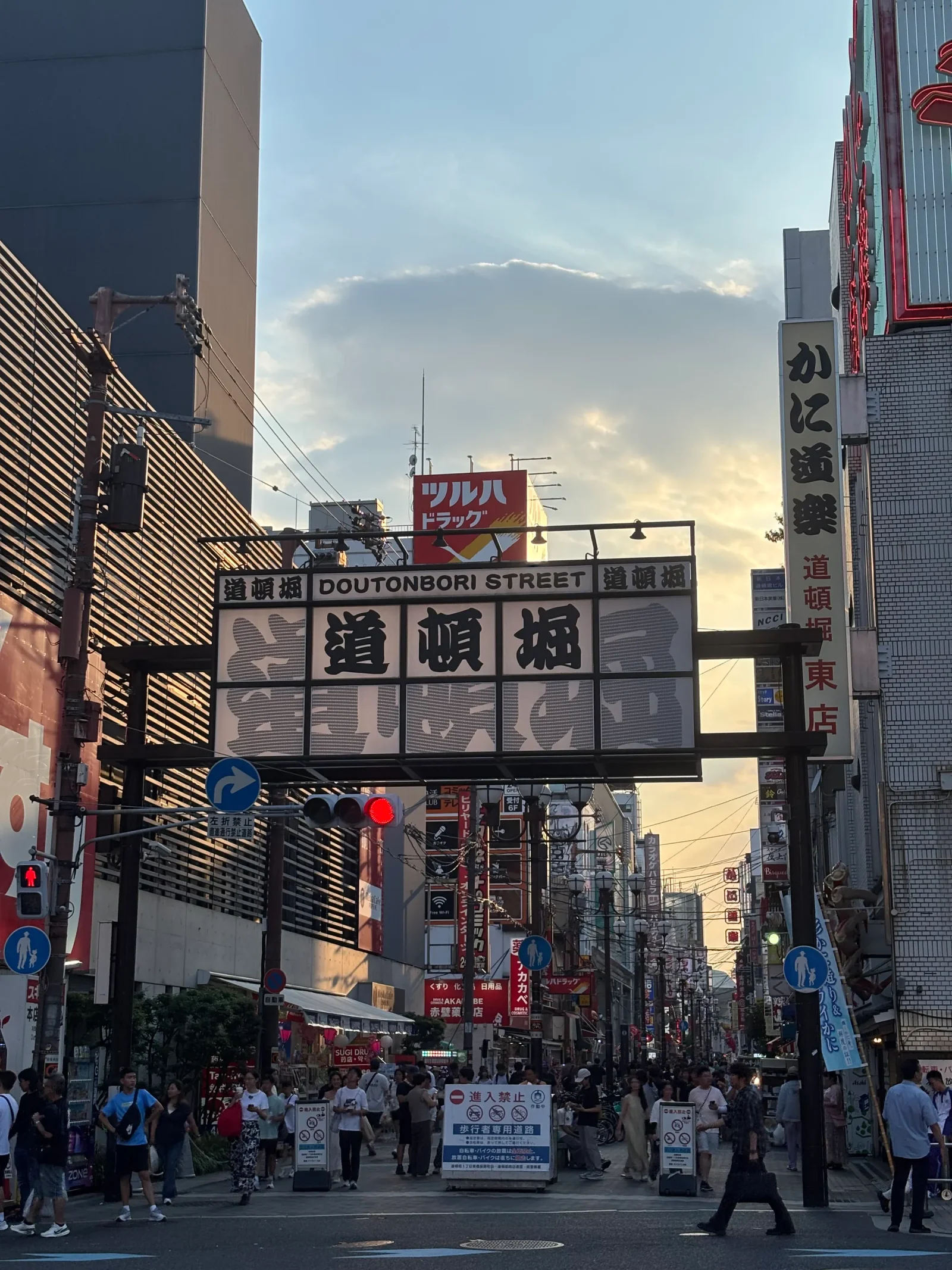 Calle de Dotonbori en Osaka al atardecer, con carteles luminosos y ambiente animado