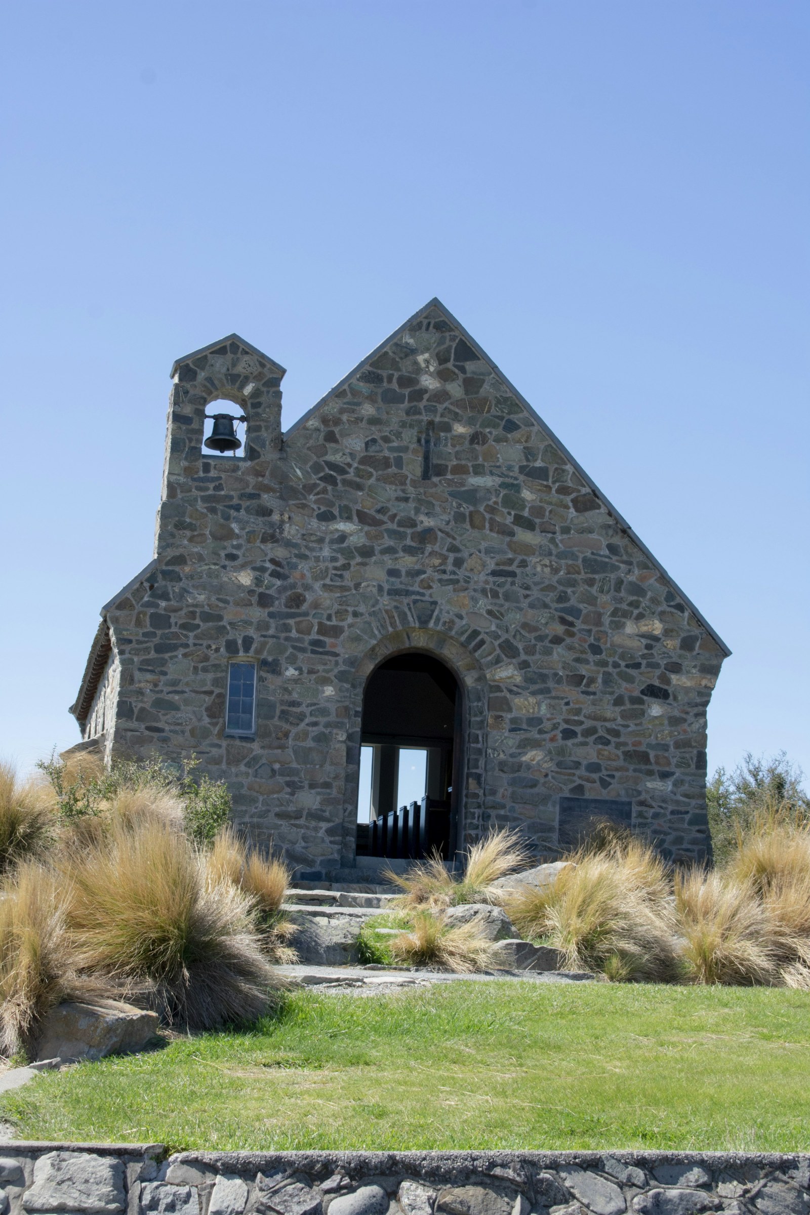 La iglesia de piedra del Buen Pastor junto a las aguas turquesa del lago Tekapo, en la Isla Sur de Nueva Zelanda