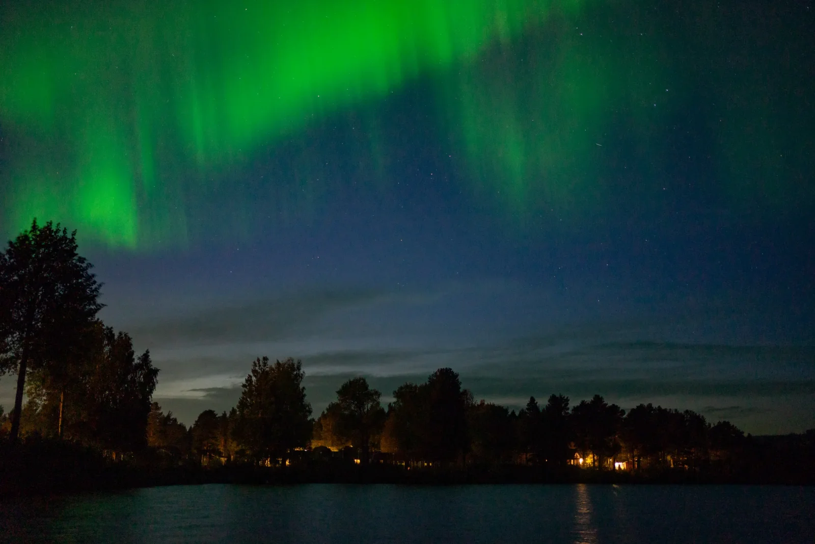 Aurora boreal verde sobre un paisaje nevado en Kiruna, en la Laponia sueca, con el cielo nocturno despejado