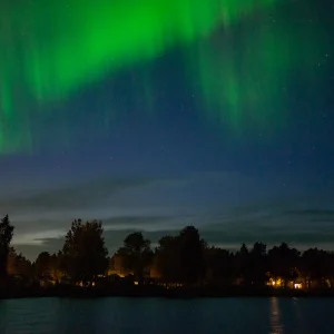 Aurora boreal verde sobre un paisaje nevado en Kiruna, en la Laponia sueca, con el cielo nocturno despejado