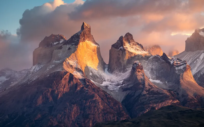 Vista panorámica del macizo de Torres del Paine al atardecer, con las cumbres de granito iluminadas de naranja