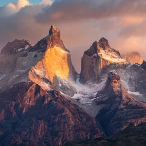 Vista panorámica del macizo de Torres del Paine al atardecer, con las cumbres de granito iluminadas de naranja