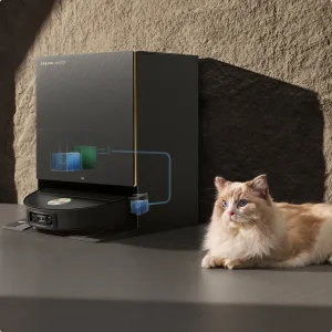 Estación base negra del Dreame X60 Max Ultra con el robot acoplado y un gato al lado