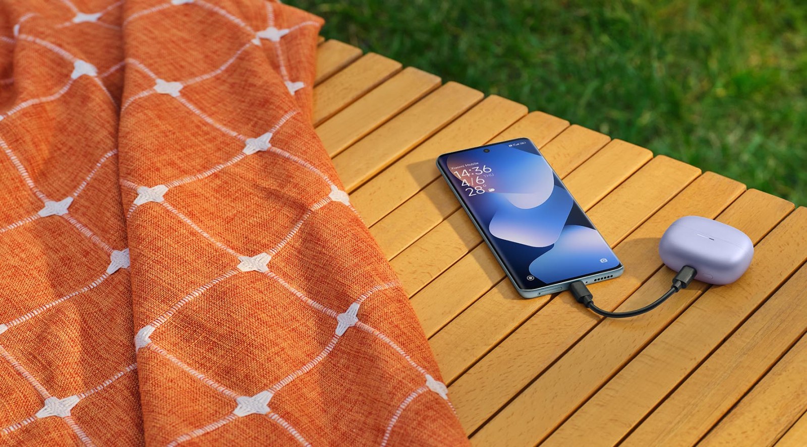 Redmi Note 15 sobre una terraza de madera junto a unos auriculares