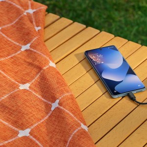 Redmi Note 15 sobre una terraza de madera junto a unos auriculares