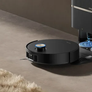 El robot Dreame L60 Pro Ultra sale de su estación y avanza por el suelo junto a una alfombra