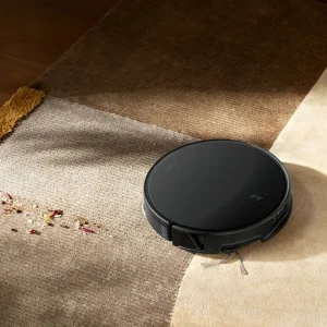 El Roborock Saros 20 aspira migas sobre una alfombra a la luz del atardecer