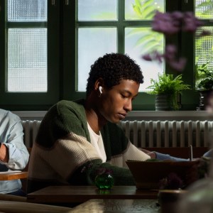 Una persona usa los AirPods 5 en una cafetería